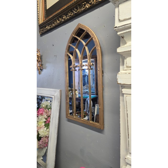 This mirror has a gold metal frame , along with metal detailing on the front making it Cathedral style. Petite in size,...