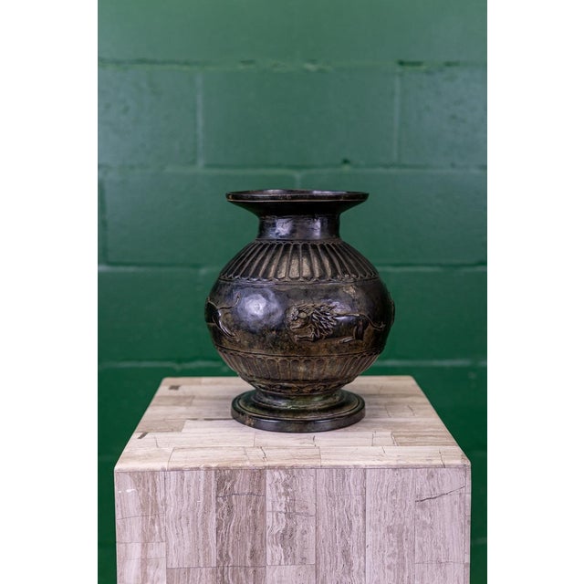 Cavorting lion motif on body and stylized floral motif etching on rim. A stunning bronze vase, hand forged and decorated...