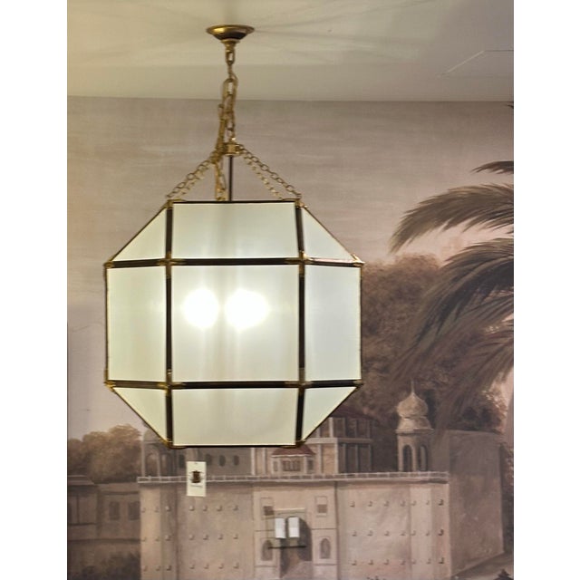 Large Octagonal Lantern Chandelier in a bronze-copper finish having antique brass accents and frosted glass. A beautiful...