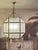 Large Octagonal Lantern Chandelier in a bronze-copper finish having antique brass accents and frosted glass. A beautiful...