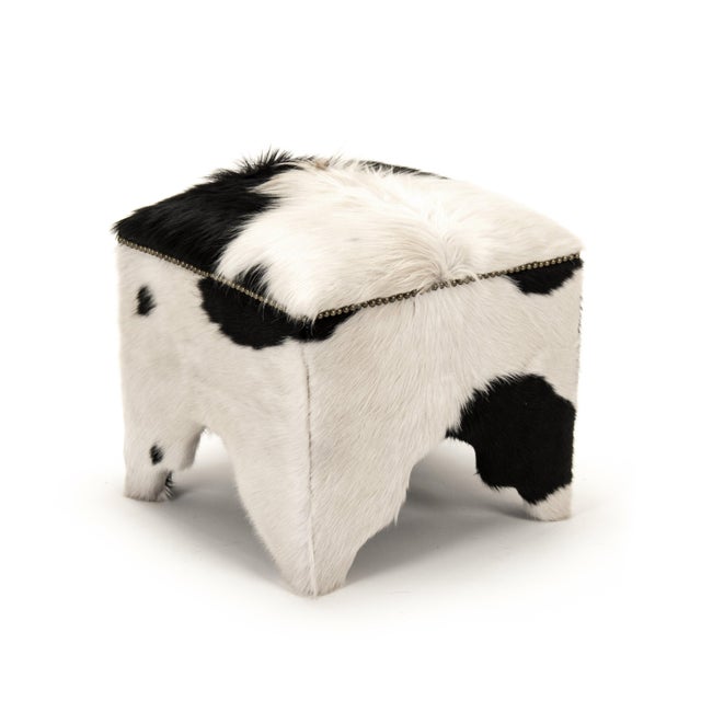 This is a stool featuring a sophisticated design with cowhide upholstery. The upholstery showcases a natural cowhide...