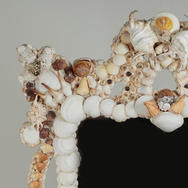 Impressive large scale shell encrusted wall mirror featuring an elaborate architectural frame lavishly adorned with an...
