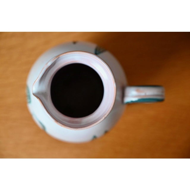 Recognizable by its colors and tribal-inspired design, this large pitcher by Yvon Roy is a beautiful piece from the 1950s....