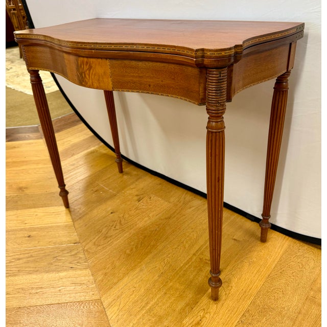 Experience the timeless elegance of early American design with this exquisite Federal style mahogany folding card game...