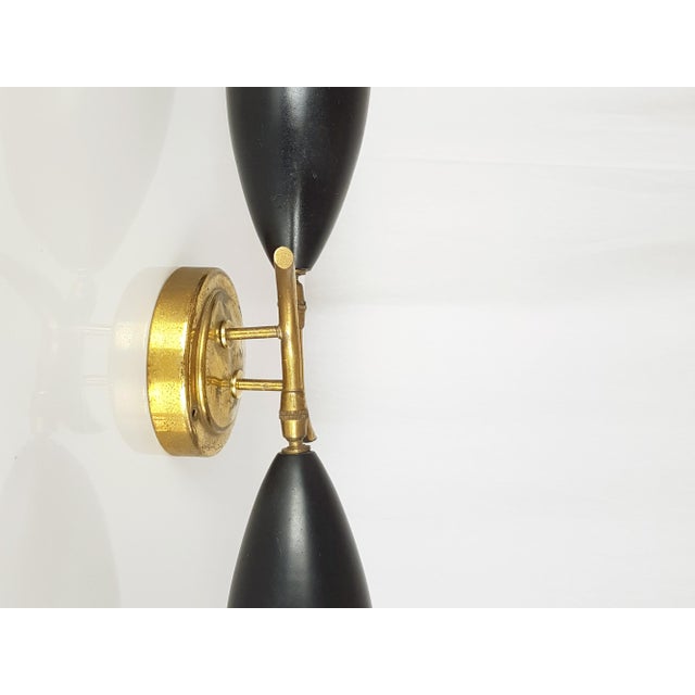 This decorative 2-light sconce was produced around the 1950s. It is made from 2 adjustable painted aluminum shades joined...