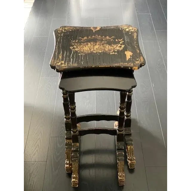 This charming 19th Century nest of tables is painted in Gold Chinorserie on Black Lacquer. The legs are carved with Dragon...