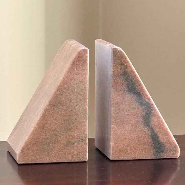 A substantial pair of vintage solid pink marble bookends featuring a clean, sculptural wedge silhouette. The softly...