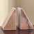 A substantial pair of vintage solid pink marble bookends featuring a clean, sculptural wedge silhouette. The softly...