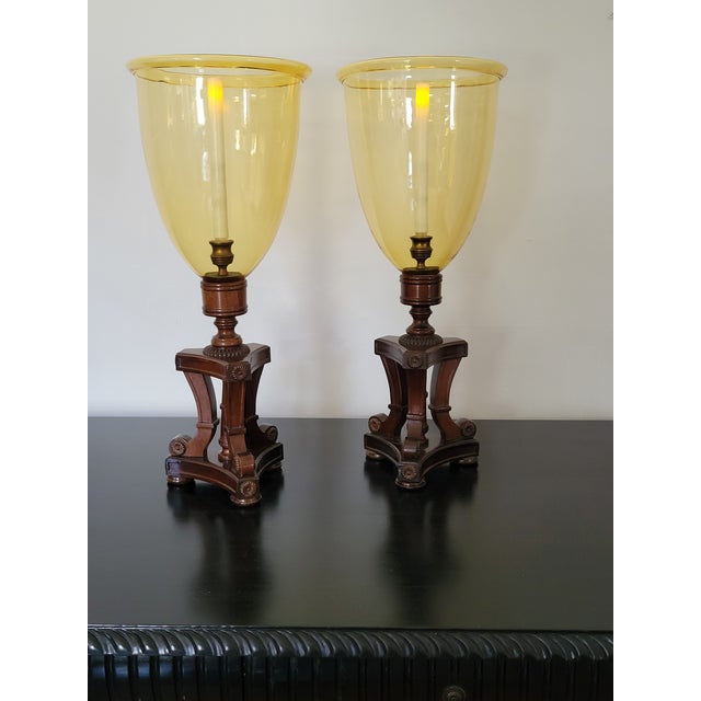 Attractive pair boasting fine carved mahogany bases with large amber glass shades.