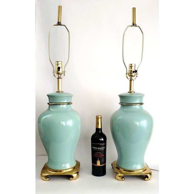 Offering a pair of soft turquoise ceramic and brass Chinoiserie style table lamps, circa 1980s.. These lovely RESTORED...
