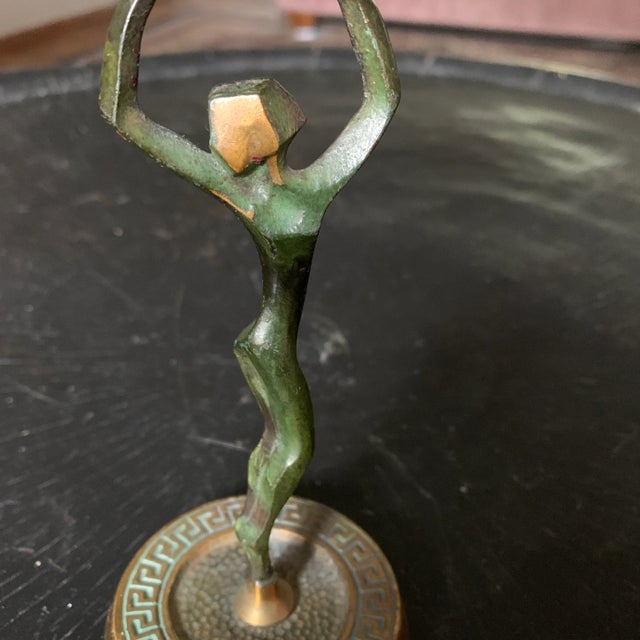 Mid-century and made in Israel, this small and lightweight metal sculpture of a woman holding a bowl is very striking and...