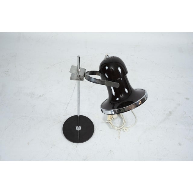 Authentic Mid-Century Modern table lamp produced in Italy during the 1960s. Featuring a sleek black round base, a vertical...