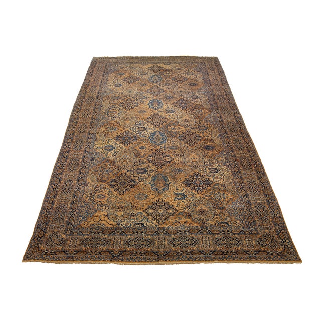Hand-knotted Persian Kerman wool rug with rust-colored field. Features an allover motif with blue and brown accents. This...