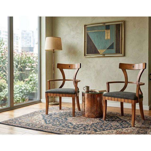 A handsome pair of vintage Empire Revival armchairs crafted in solid wood with a warm medium-brown finish and elegant...