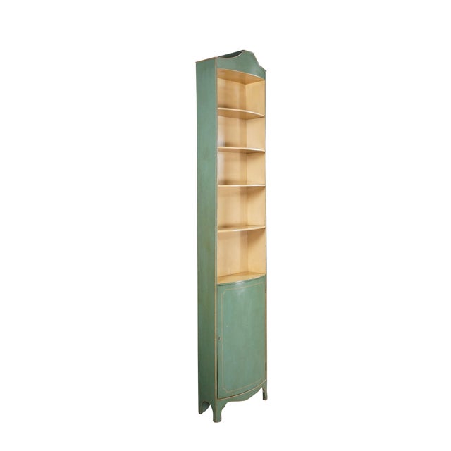 This petite green corner cabinet features a distressed sage green exterior with gold pinstripe trim and a scalloped arched...