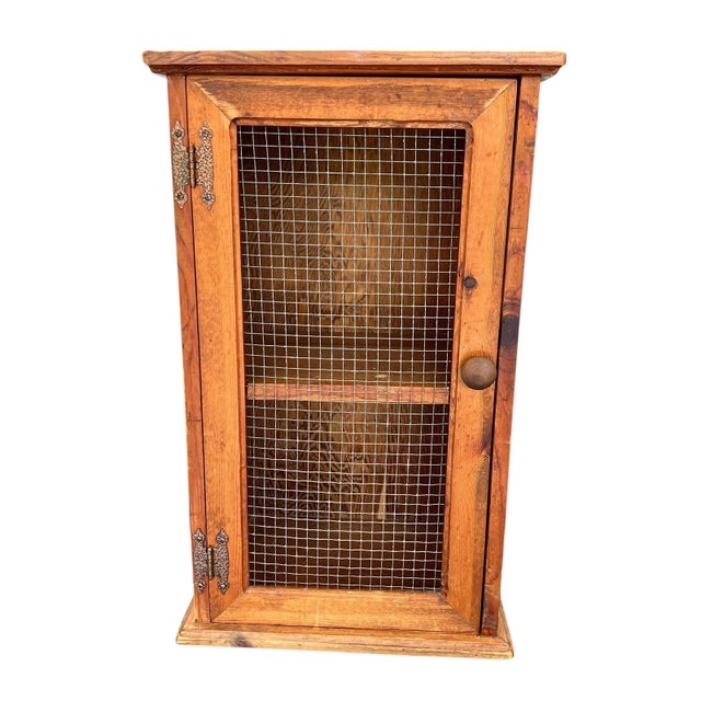 Mid century natural wood (no finish) knotty pine cabinet. One door with wire panel. Interior has two shelves. Measures...