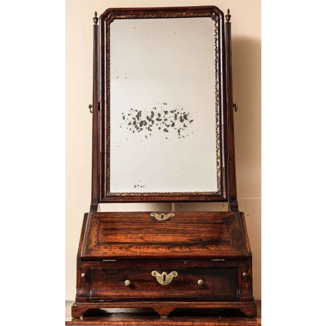 The rectangular mirror plate with cusped top corners within a conforming incised gilt surround and molded hinged wood...