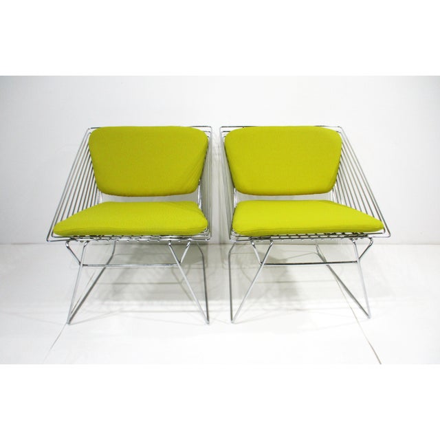 A pair of very well-crafted 1970's chrome wire styled lounge chairs with tight woven double lemon-yellow upholstered...