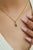 This elegant pendant showcases a 0.66 carat natural zambian pear-cut emerald, set in 14k yellow gold. The emerald...