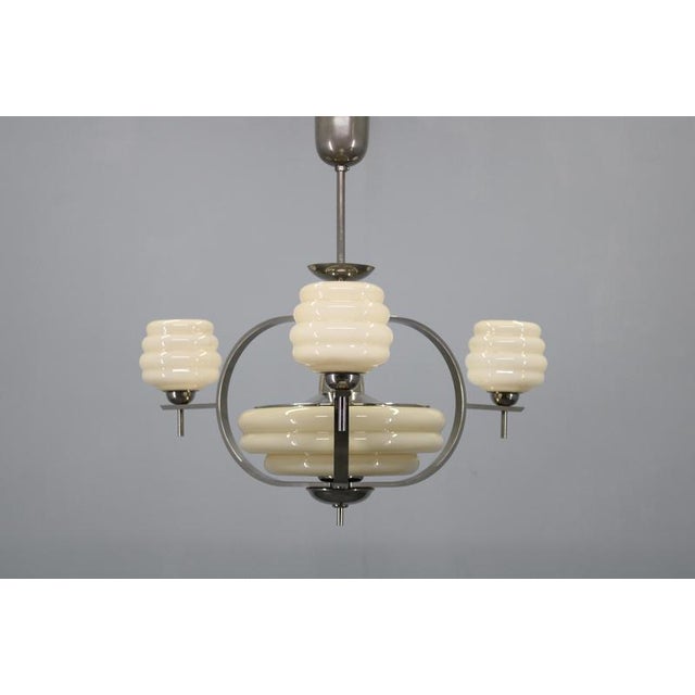 Striking 1930s art deco chandelier produced in czechoslovakia. The composition features nickel-plated metal framing a...