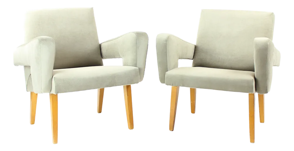 Two mid-century armchairs with wooden legs on a white background.