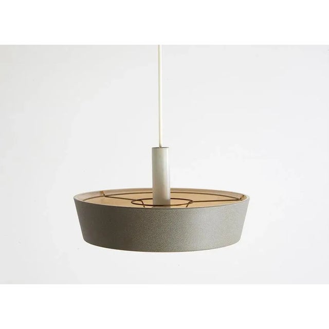 Rare pendant lamp designed by Niek Hiemstra in the 1960s for Hiemstra Evolux. It has a dark grey hammered metal shade, a...