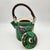 Japanese green-glazed ceramic teapot with hand-painted floral motifs and woven rattan handle