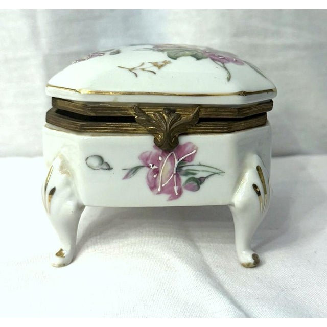 Lovely porcelain dresser box by Kalk. Set on feet, hand-painted with roses, and with ormolu fixtures