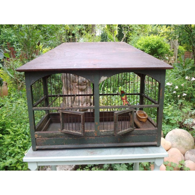 An antique birdcage from France, with a very decorative roof shape and arched wire panels. It dates from around 1850 and...