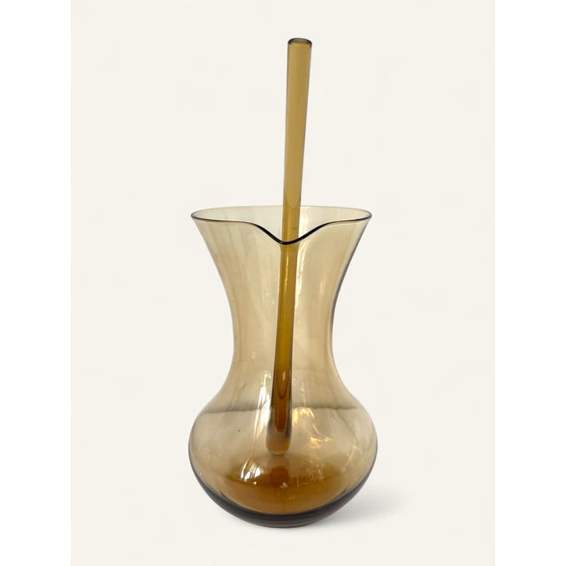 Serve in sculptural style with this striking Mid-Century Modern handblown glass cocktail pitcher, featuring a sultry...