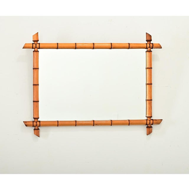 A faux-bamboo mirror from France, turn of the century circa 1890, made of carved pine with subdued grain patterns to...