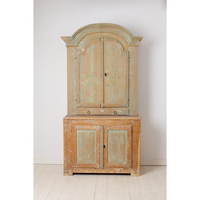 Antique country rococo cabinet from northern Sweden. This country house furniture was made around 1820 with a frame in...
