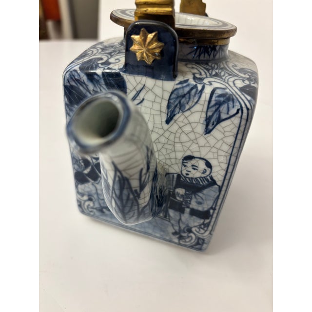 Chinese blue and white porcelain teapot with brass mounting. The teapot is decorated with an underglaze blue design,...