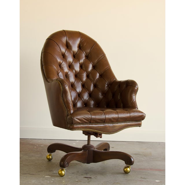 A commanding take on the classic English library chair, this vintage executive swivel chair pairs a tall, gracefully...