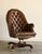 A commanding take on the classic English library chair, this vintage executive swivel chair pairs a tall, gracefully...