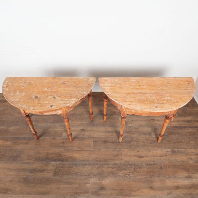 Late 19th century Swedish pair of demi lune console tables, crafted in pine and retaining their original painted finish....