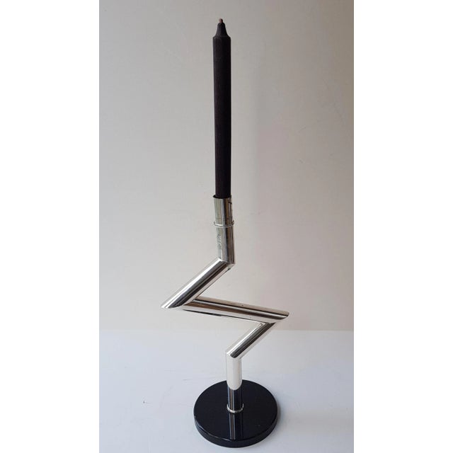 This is a silvered zig-zag shaped candle holder on a round granite base. This piece has an attribution mark, I am sure...