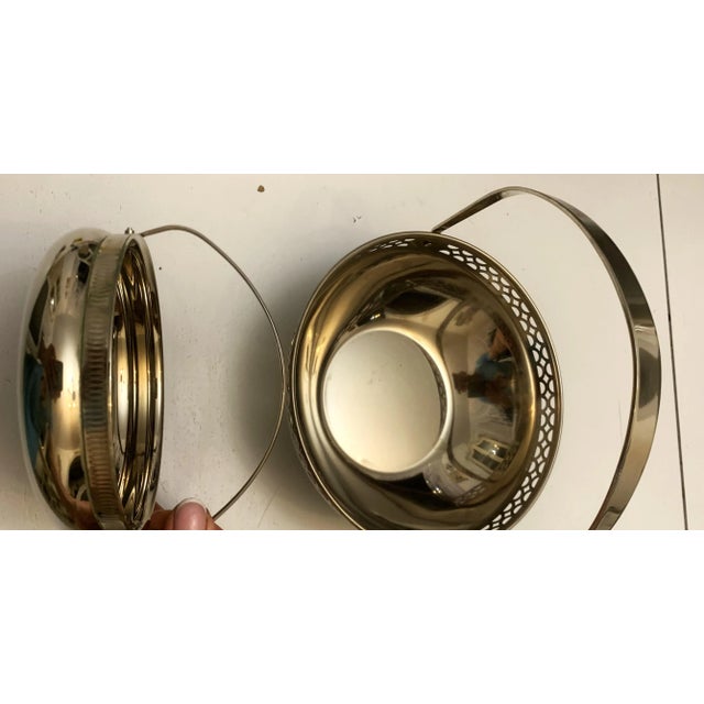 A set of two metal baskets with handles, made of solid plated metal (chrome/nickel). the smaller piece is marked mfi r – a...