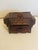 A charming hand-carved wooden box featuring richly textured geometric detailing and a warm, aged patina. Crafted with...