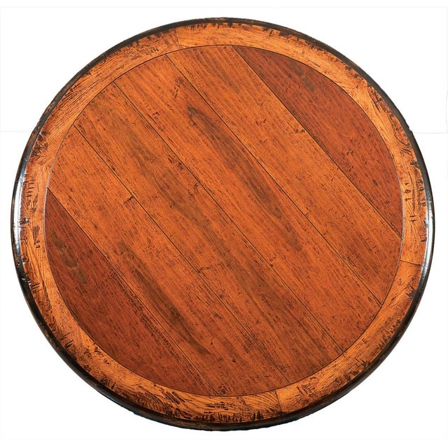 Handcrafted in Italy from solid walnut, this round dining table features a warm distressed finish accented by a...