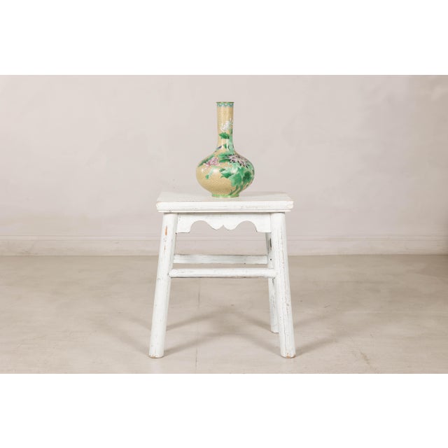 This vintage Chinese wooden stool features a simple country form elevated by a beautifully weathered white-painted finish....