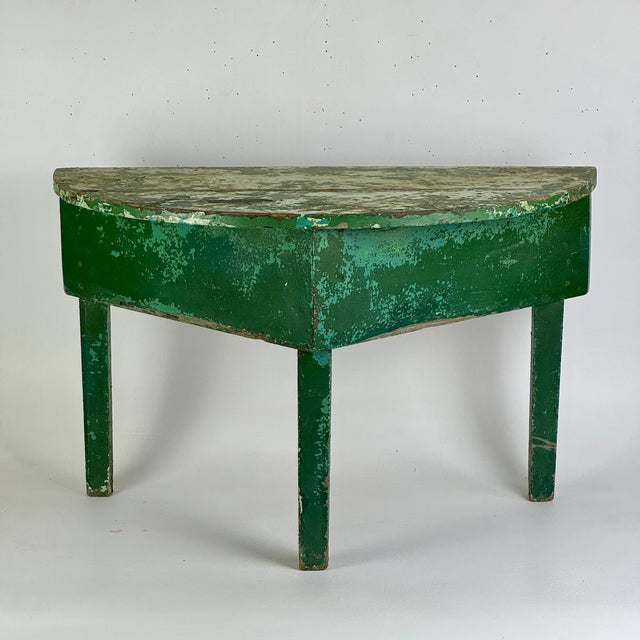 A unique sculptural table marrying a demilune (crescent) top with a triangular 3 legged base. Add to it the avocado green...