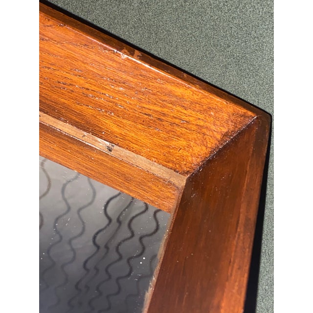 Elevate your space with this vintage circa 1970s Danish Modern teak shadow box wall mirror by Pedersen & Hansen. Expertly...