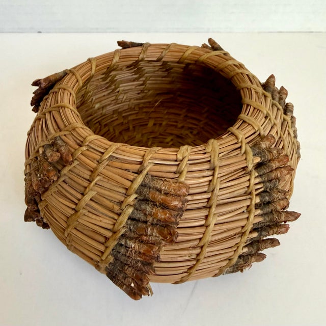 Here is a charming vintage handwoven pine needle trinket bowl, possibly dating to the later mid-20th century. The small,...