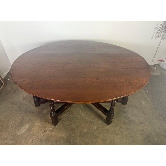 This handsome English gateleg dining table is crafted from richly grained oak and features a generous oval top supported...