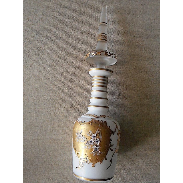 This vintage cased glass decanter dates to the mid 20th century. It is profusely decorated with 24K gold trim and...