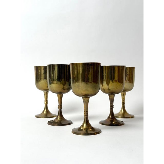 A beautiful set of five vintage brass wine goblets, most likely dating from the 1960s to 1970s. Each goblet has an...