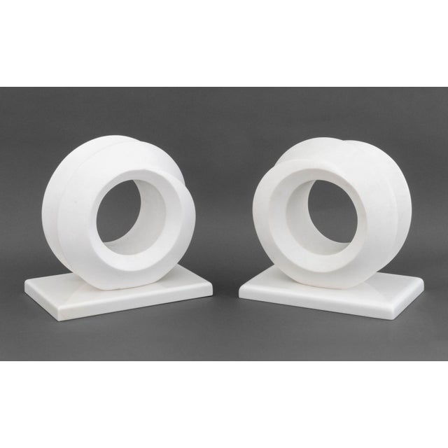 Pair of Modern Carved White Quartzite Sculptures, each in the form of a geometric circular spiral atop a white marble...