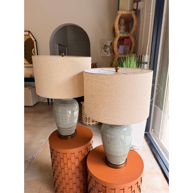 This transitional table lamp features a beautifully glazed sage green ceramic base with subtle crackle detailing, paired...