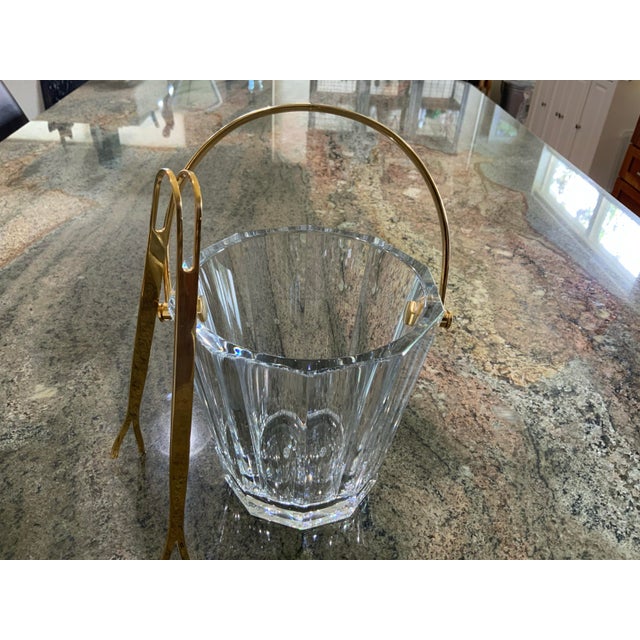 Elegant vintage Baccarat crystal ice bucket featuring a beautifully faceted clear crystal body with gold-tone metal swing...
